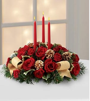 The Celebration of the Season™ Centerpiece by FTD® - The Celebration of the Season™ Centerpiece by FTD® is a grand display of holiday elegance. Red roses and spray roses pop against a backdrop of assorted holiday greens and variegated holly that beautifully encircle three red taper candles. Accented with gold pinecones and gold metallic brocade ribbon, this centerpiece creates a warm and enchanting glow to benefit their holiday festivities. BETTER bouquet is approximately 9"H x 18"W. Your purchase includes a complimentary personalized gift message.