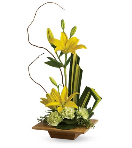 Yellow lilies in a wooden vase with green accents