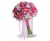 Pink and lavender bouquet with ribbon in a clear vase