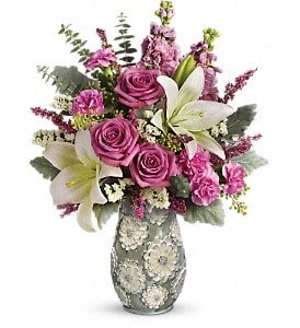 Teleflora's Blooming Spring Bouquet - These lavender roses, white asiatic lilies, pink miniature carnations, and pink stock are beautifully arranged with white sinuata statice, lavender heather, seeded eucalyptus, dusty miller, and spiral eucalyptus. Delivered in a Blooming Spring vase. Approximately 14 1/2 W x 19 H