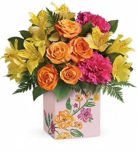 Orange roses and pink carnations in a floral-painted box