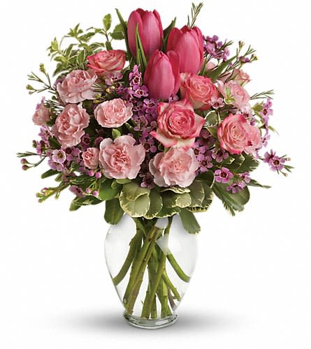 Pink tulips and roses arranged in a clear glass vase