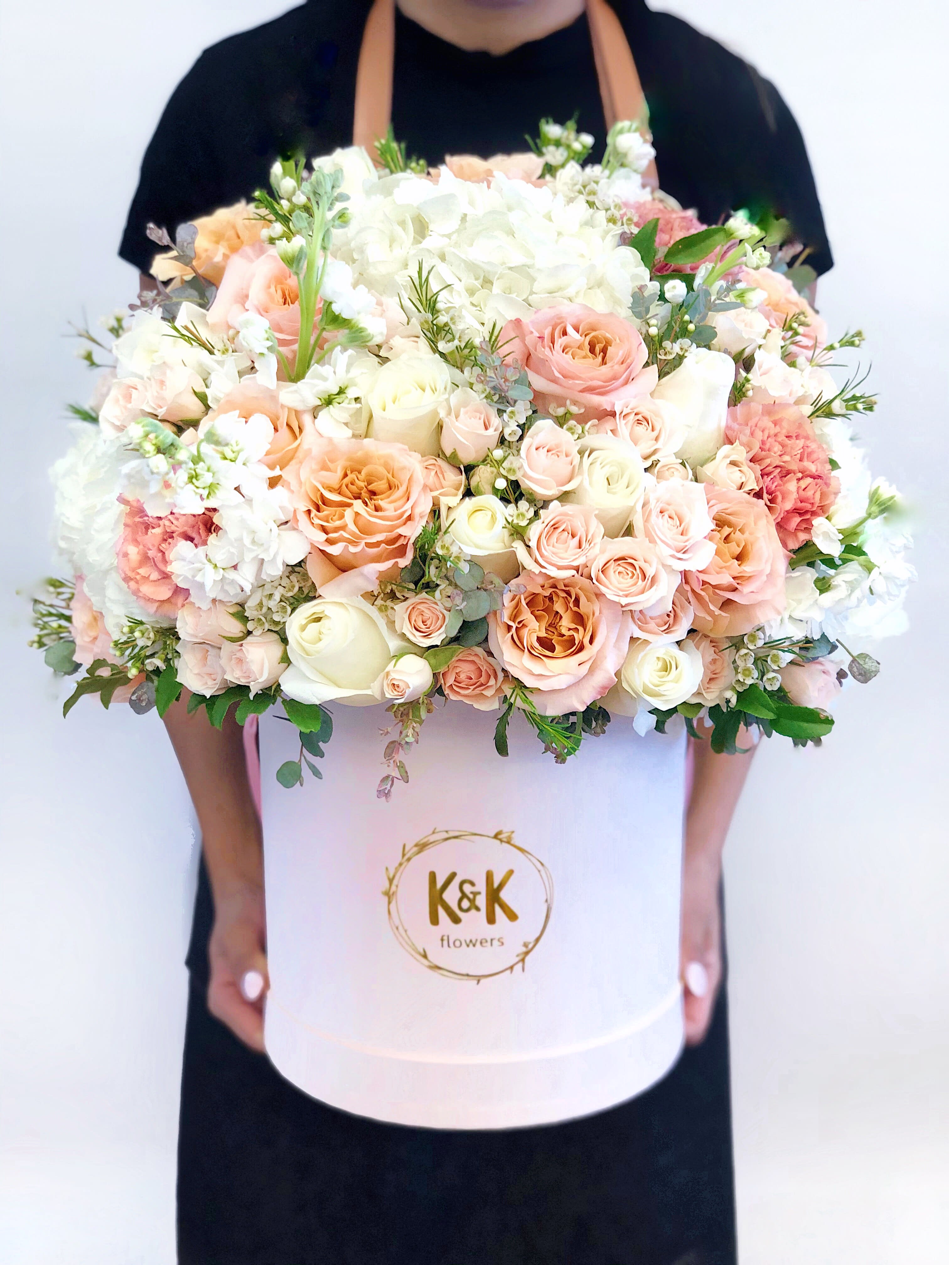 Large pastel bouquet of roses, hydrangeas, and carnations in a white hat box