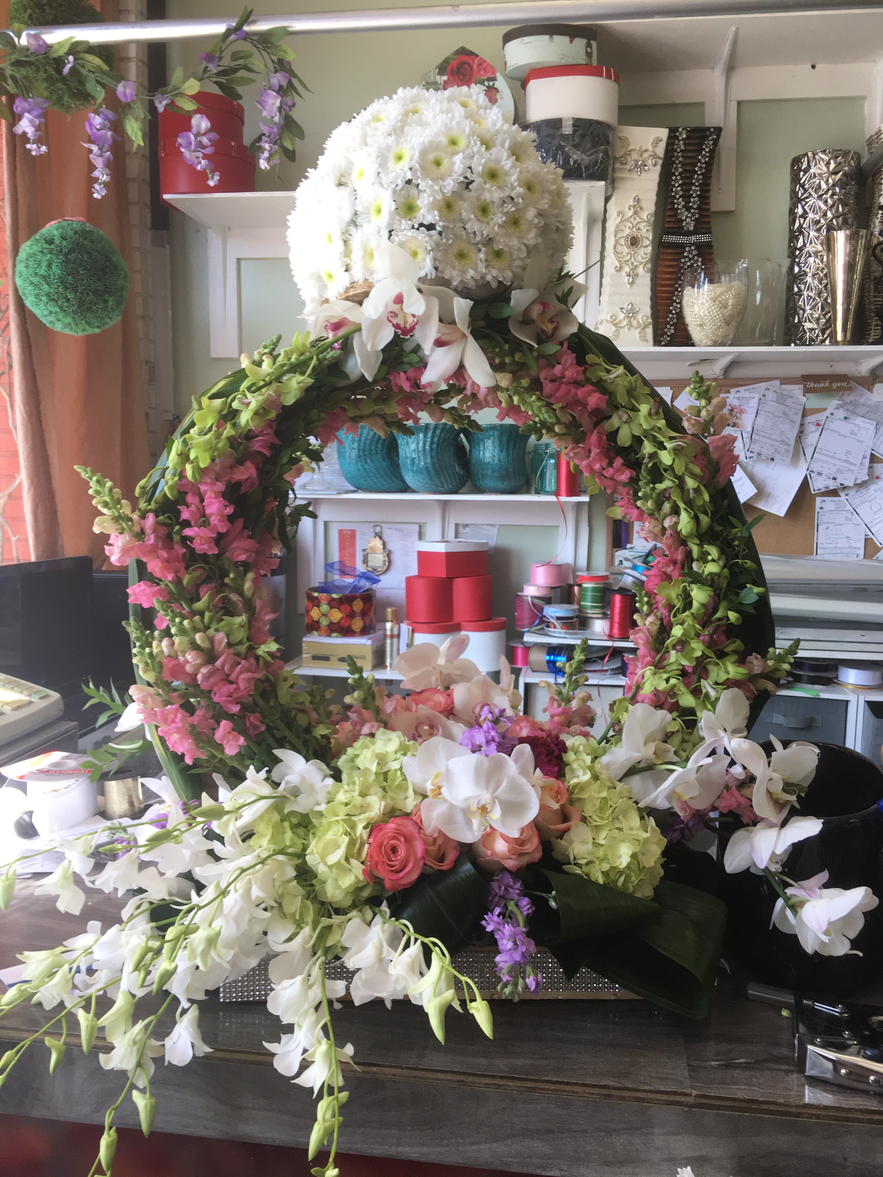 Large floral wreath with white and pink flowers on a table