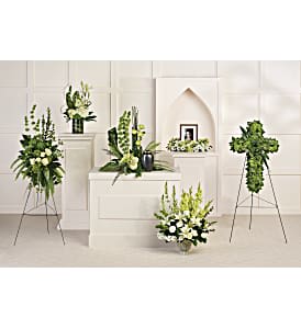 White and green funeral floral arrangements on stands and pedestals