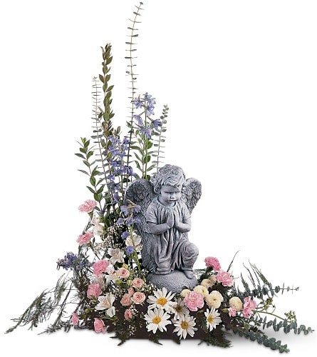 Angel statue surrounded by pink and white flowers with tall greenery