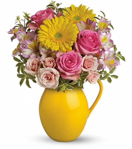 Pink roses and yellow daisies in a yellow pitcher vase