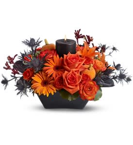 Spooky Spell - Planning a macabre Halloween party? Cast a spooky spell with this fiery centerpiece, featuring a glowing black pillar candle surrounded by brilliant orange flowers. A wonderful floral arrangement for a table, an entryway, or to light up the front window on Halloween night.