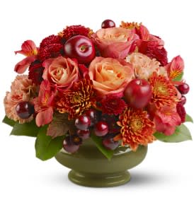 Autumn Orchard - A lush collection of burnt orange roses mixed with peach, bronze, rust and red blossoms - plus deep red grapes and apples - is arranged in a classic pedestal bowl. It's as pretty and picturesque as an orchard at harvest time and makes the perfect autumn centerpiece. 