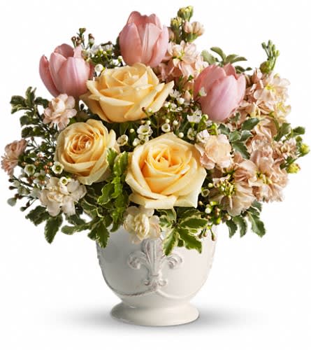 Pink tulips and pale yellow roses in a white vase