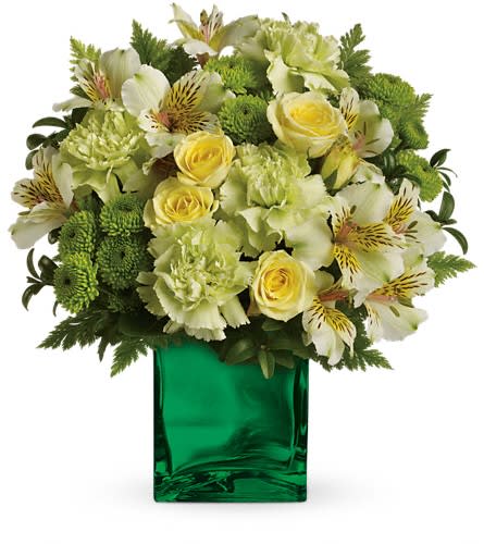 Yellow and white flowers arranged in a green glass vase