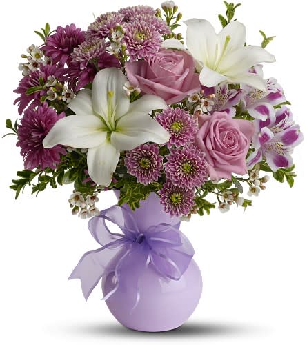 Bouquet of pink roses, white lilies, and purple flowers in a lavender vase