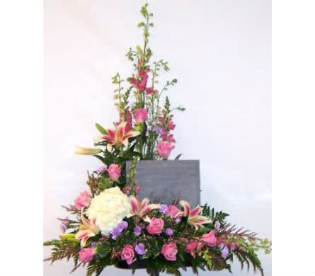 Tall floral spray with pink and white blooms around a gray plaque