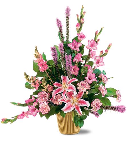 Pink lilies and mixed pink flowers in a ribbed gold vase