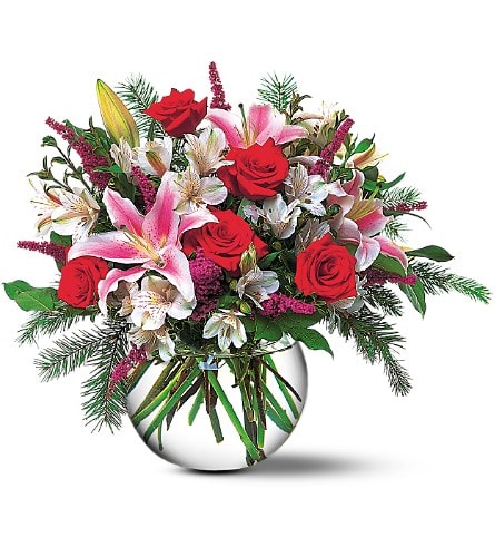 Bouquet of red roses and pink lilies in a round glass vase