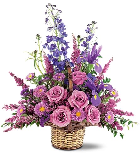 Pink roses and purple flowers arranged in a wicker basket