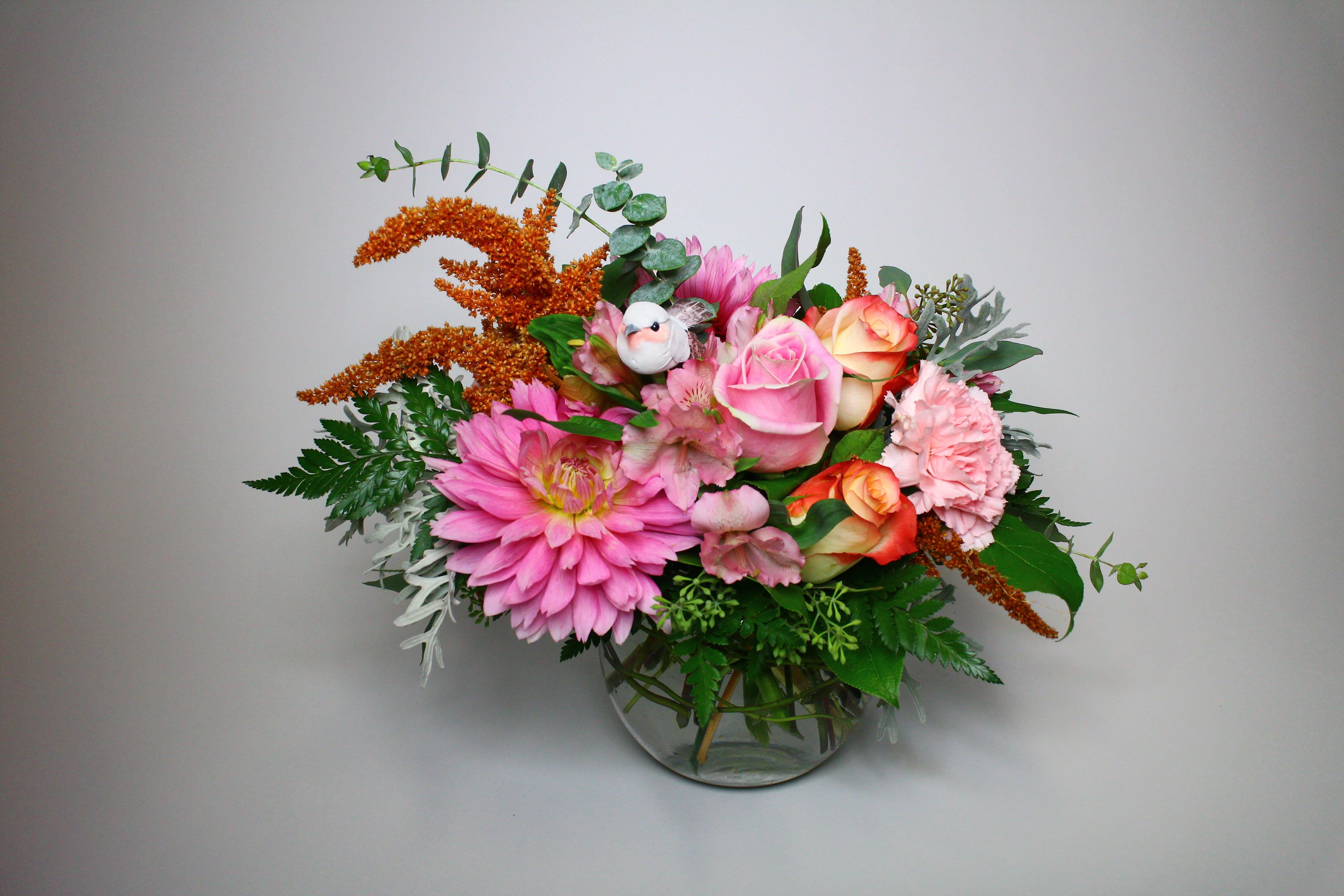 Pink and peach flower arrangement in a clear glass vase