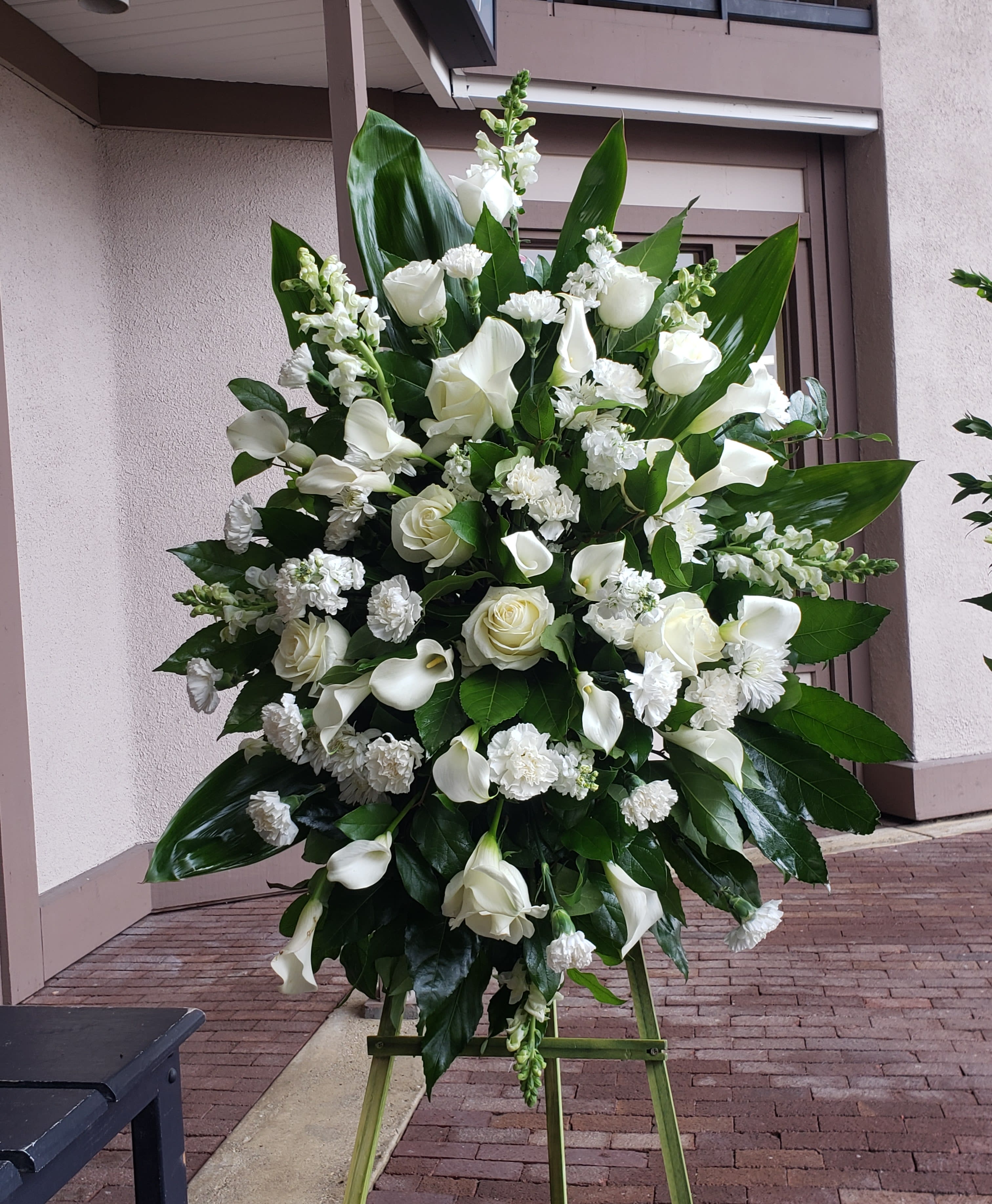 Large white floral standing spray on an easel