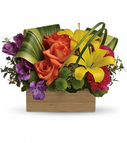 Colorful bouquet with roses and lilies in a wooden box