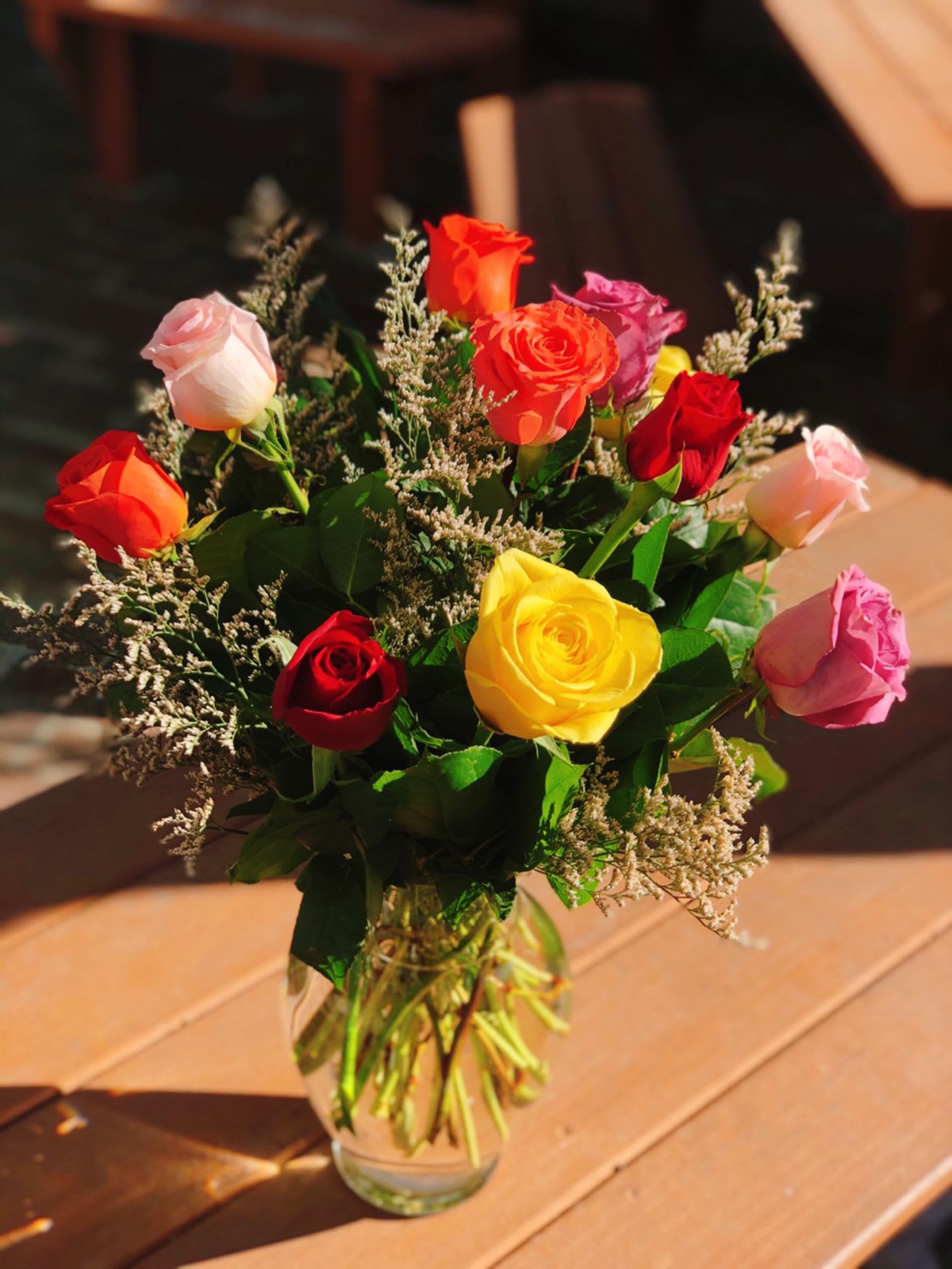 Bouquet of multicolored roses in a clear glass vase