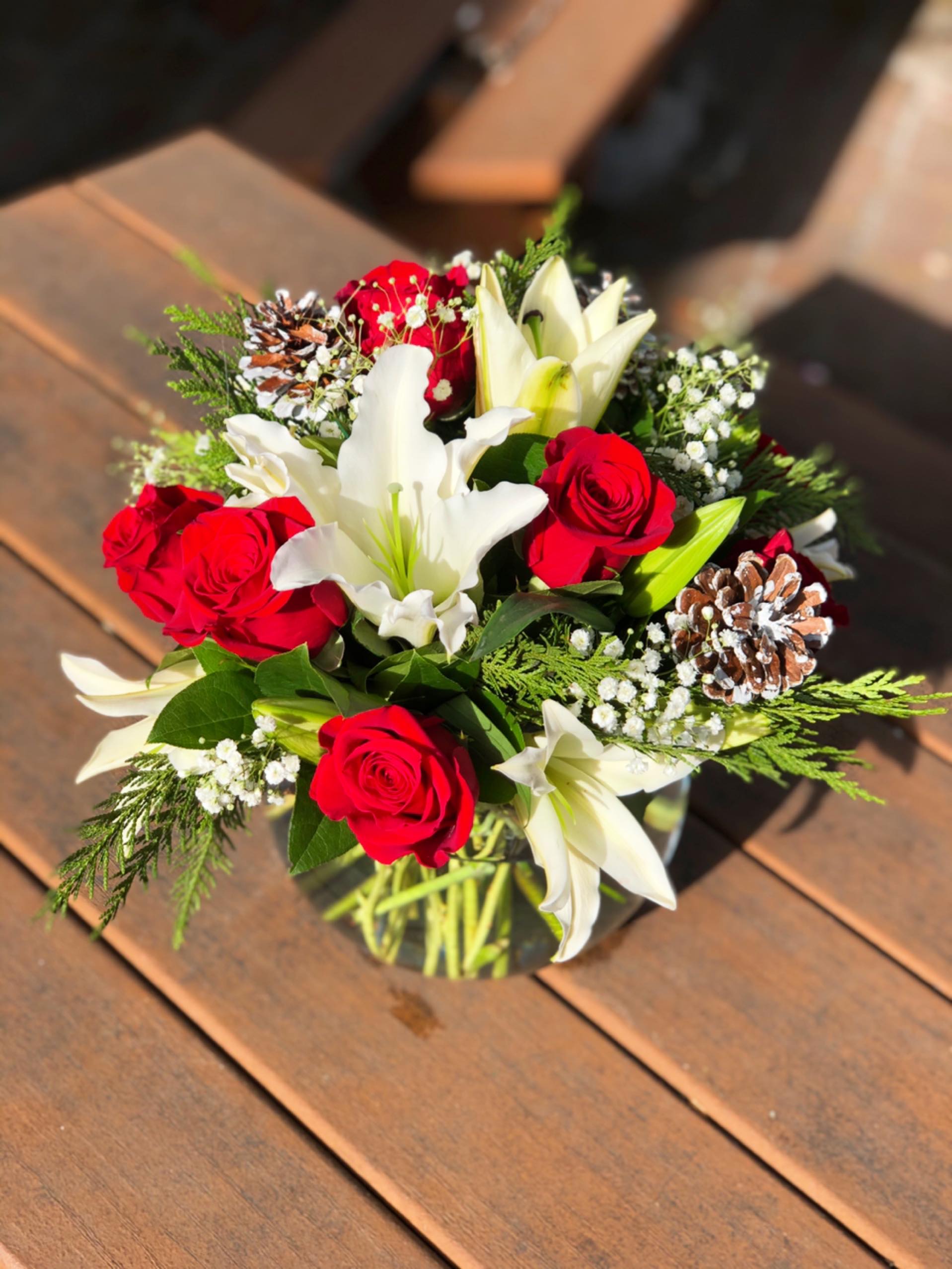 Christmas Wishes - - 3 Stems White Lilies - 8 Red Roses - Baby Breath - Pine Cones - Christmas Greens - 8 Inches Bubble Vase