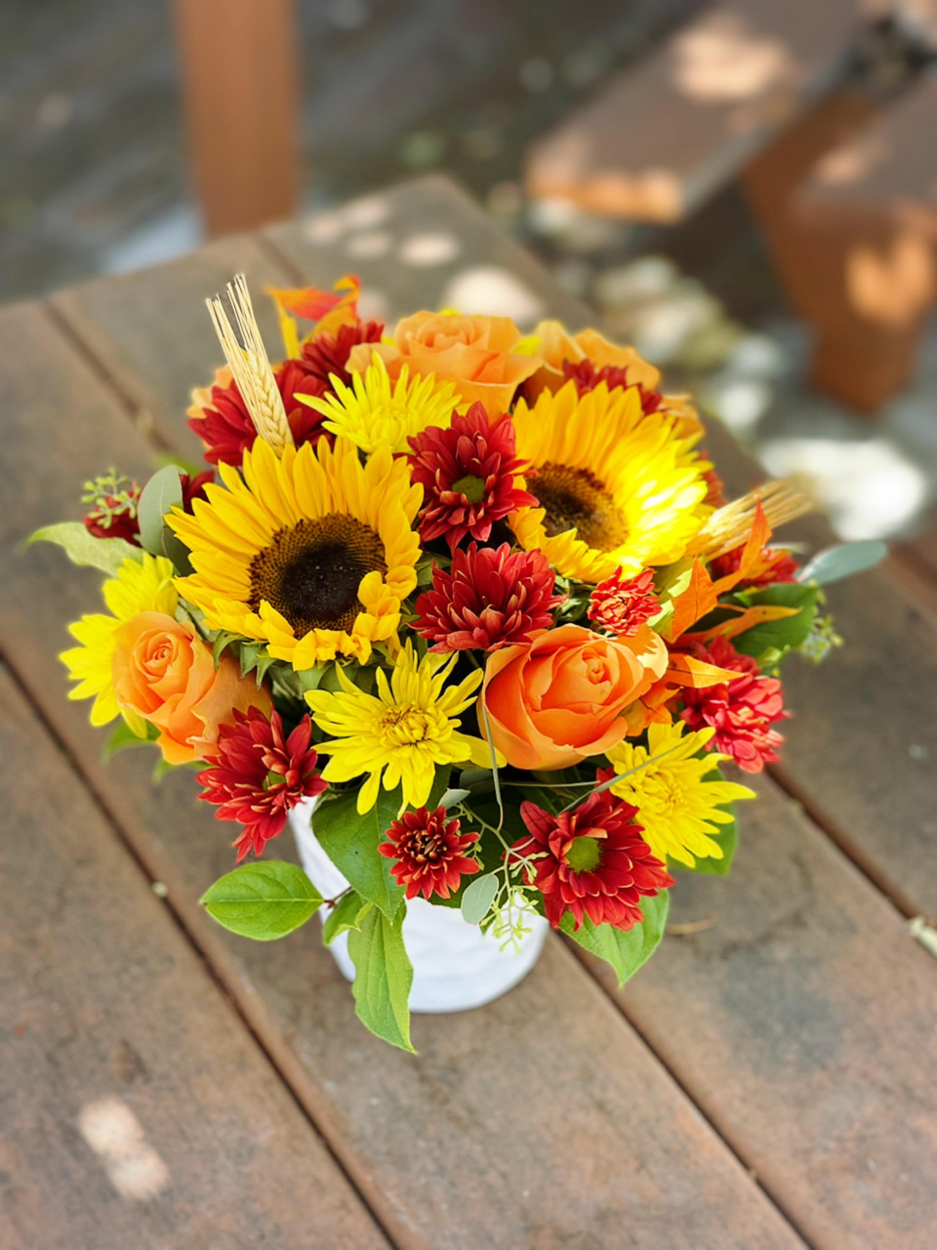 Autumn Bouquet - - 2 Sunflowers - 6 Orange Roses - 5 Red Daisies (Or Cushions) - 5 Yellow Daisies (Or Cushions) - Fall Leaves - Wheat - 6 Inches Ceramic Pot