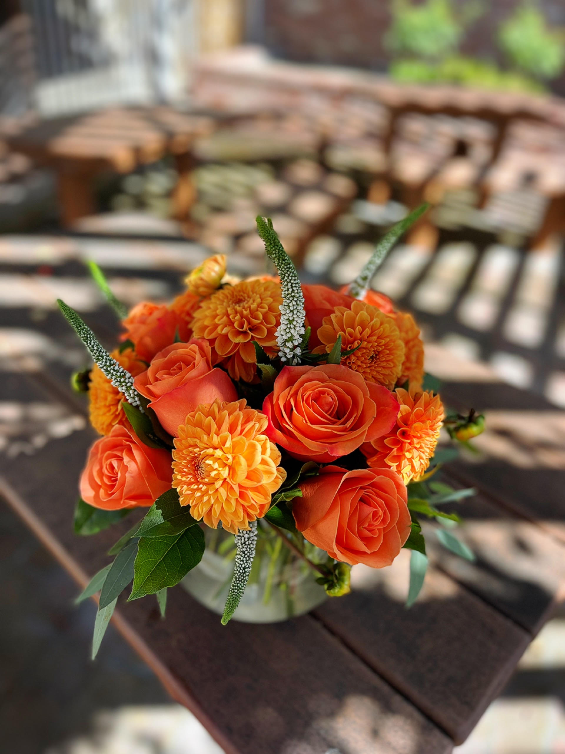 Sunrise  - -6 Orange Dahlias -6 Orange Roses -3 White Veronica -8 Inches Bubble Vase