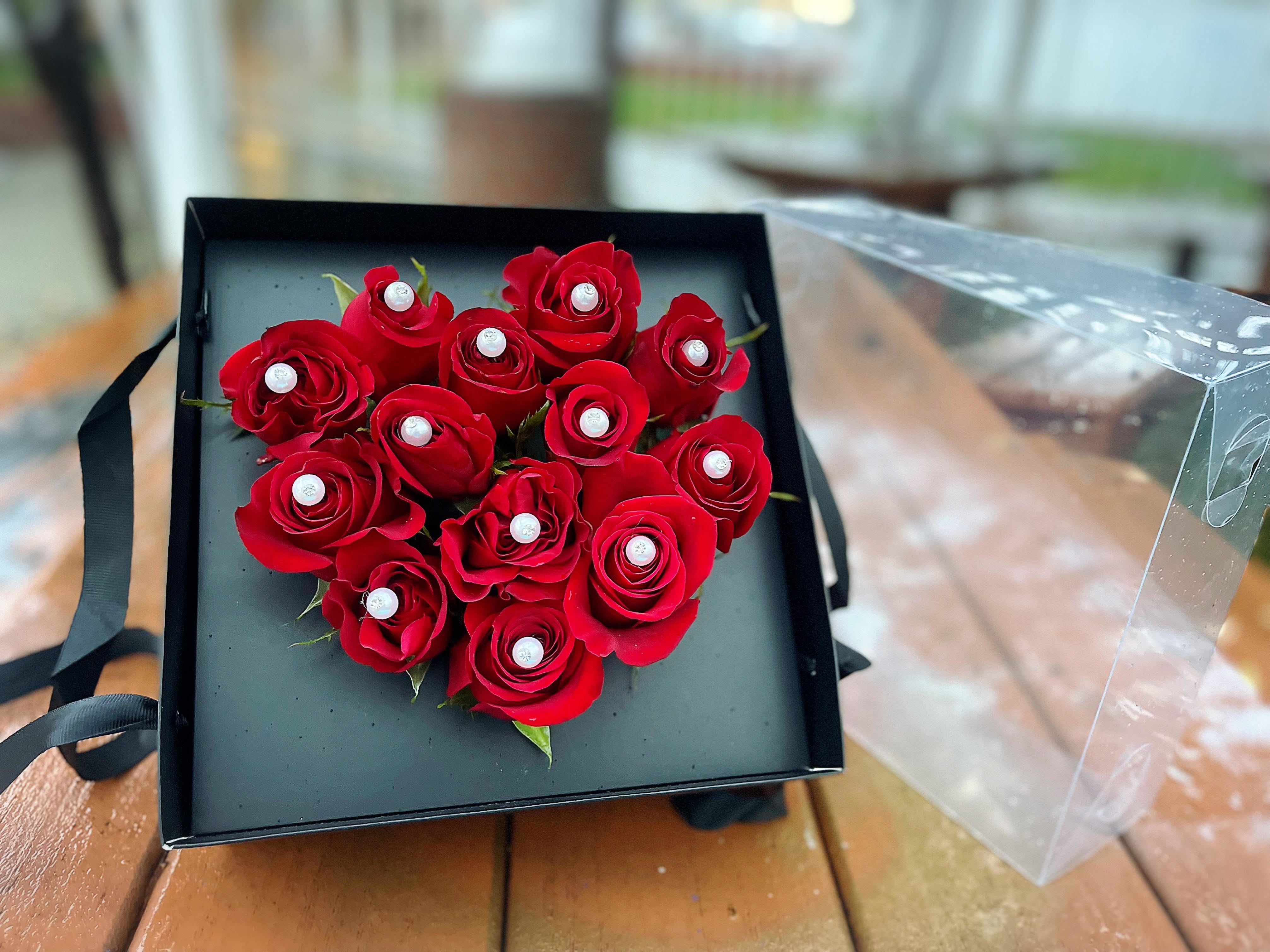 Heart-shaped box of red roses with pearl accents