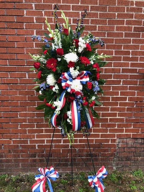 Standing patriotic floral wreath with red, white, and blue ribbons