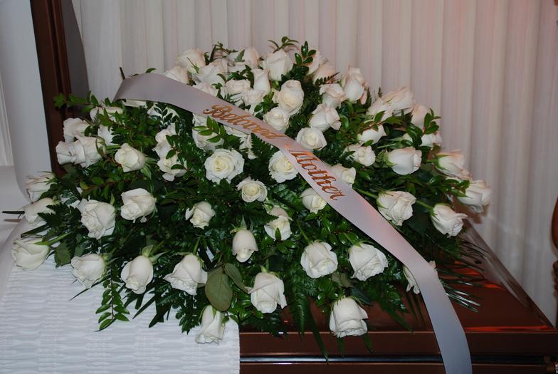 Large white rose funeral spray with a memorial ribbon