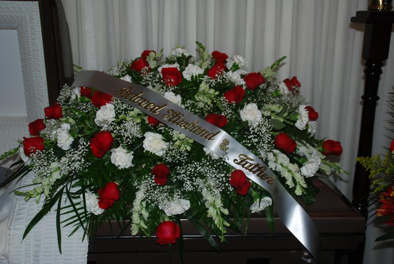 Large red and white rose funeral spray with a memorial ribbon