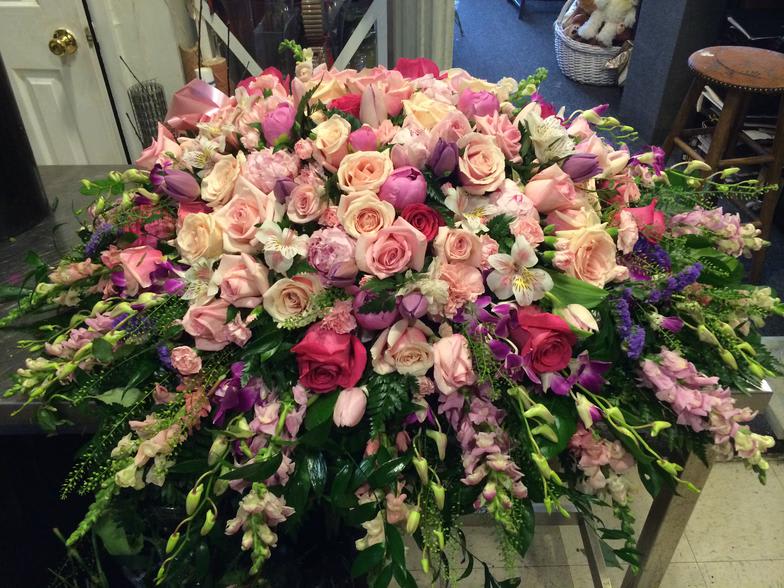Large pink and purple floral arrangement with roses and orchids