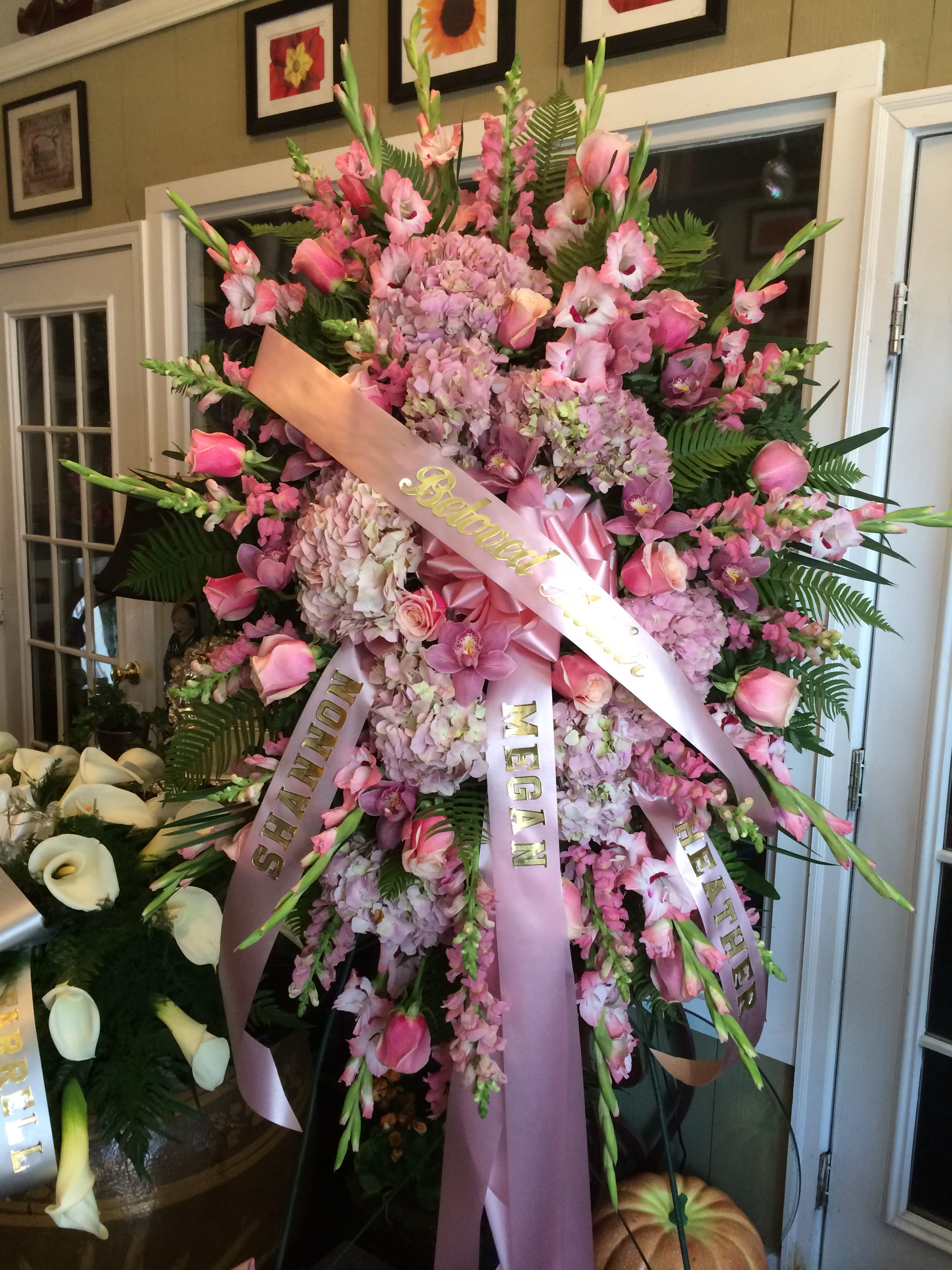 Large pink funeral spray with ribbons and orchids