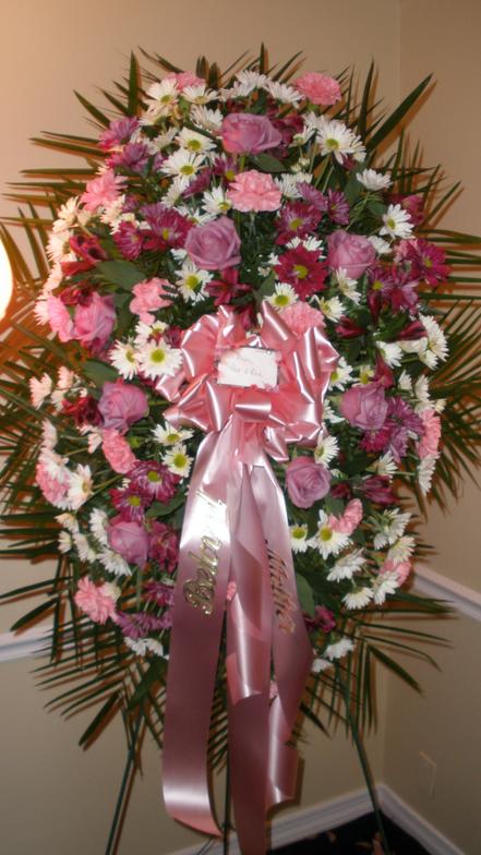Pink and white floral standing spray with a pink ribbon