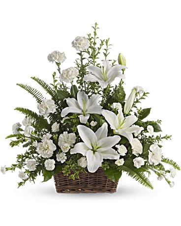 Peaceful White Lilies Basket - Whether you send this beautiful arrangement to the family home or to the service, all will appreciate its elegance and grace. The contrast of brilliant white blossoms and dazzling greenery create a wonderfully calm and dignified setting. Gorgeous flowers such as white lilies, carnations and miniature carnations mix with vibrant greens in a large basket. Simply stunning.