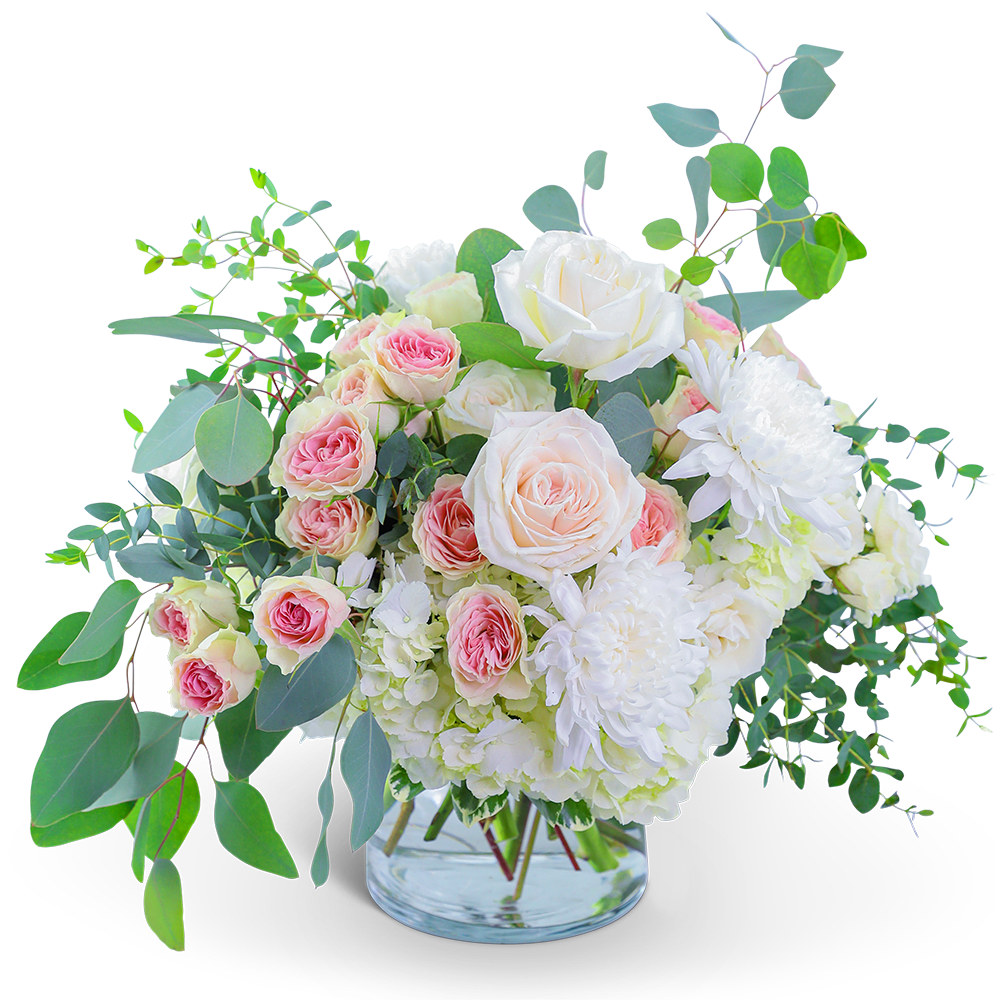 Pink and white roses with white blooms in a clear glass vase