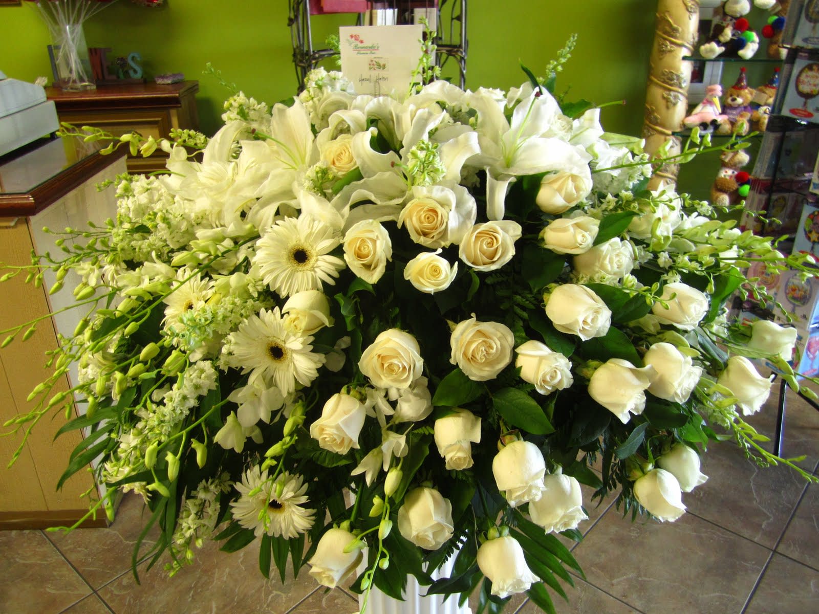 Large white floral arrangement with roses, lilies, and daisies