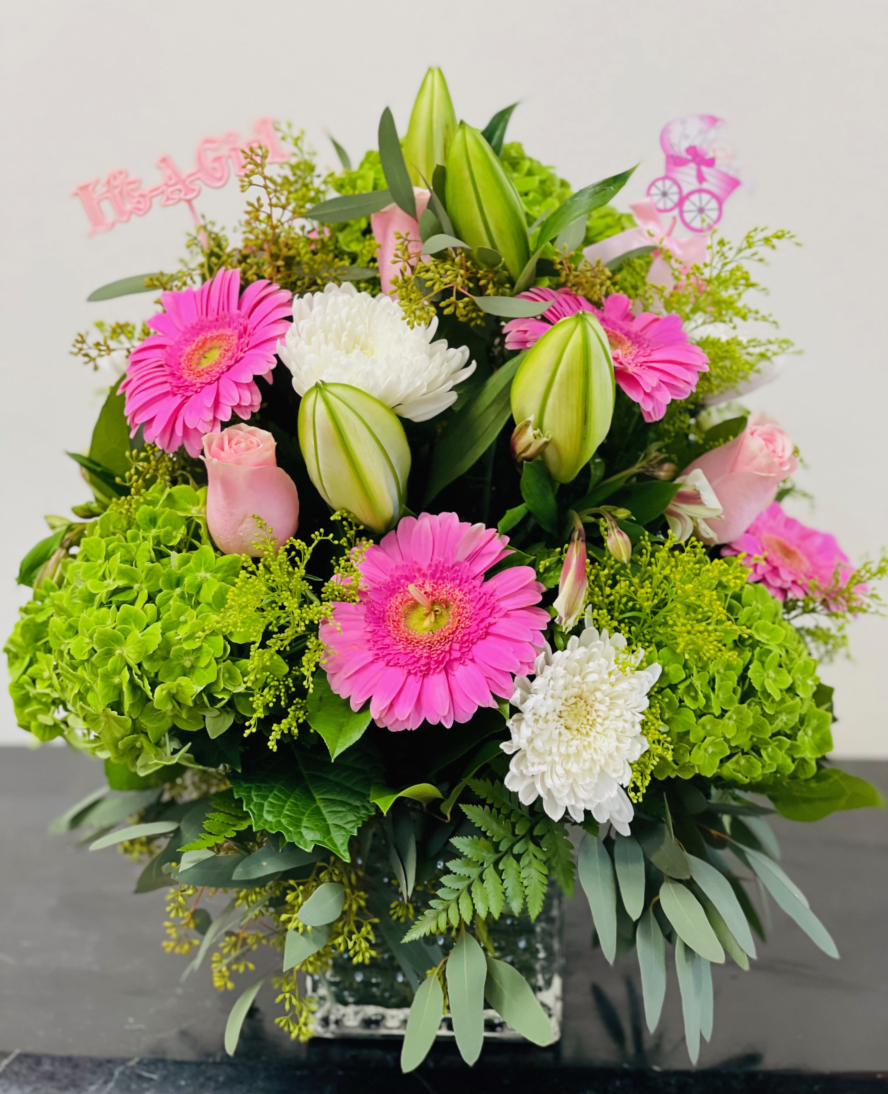 Pink gerbera daisies and white chrysanthemums in a glass vase