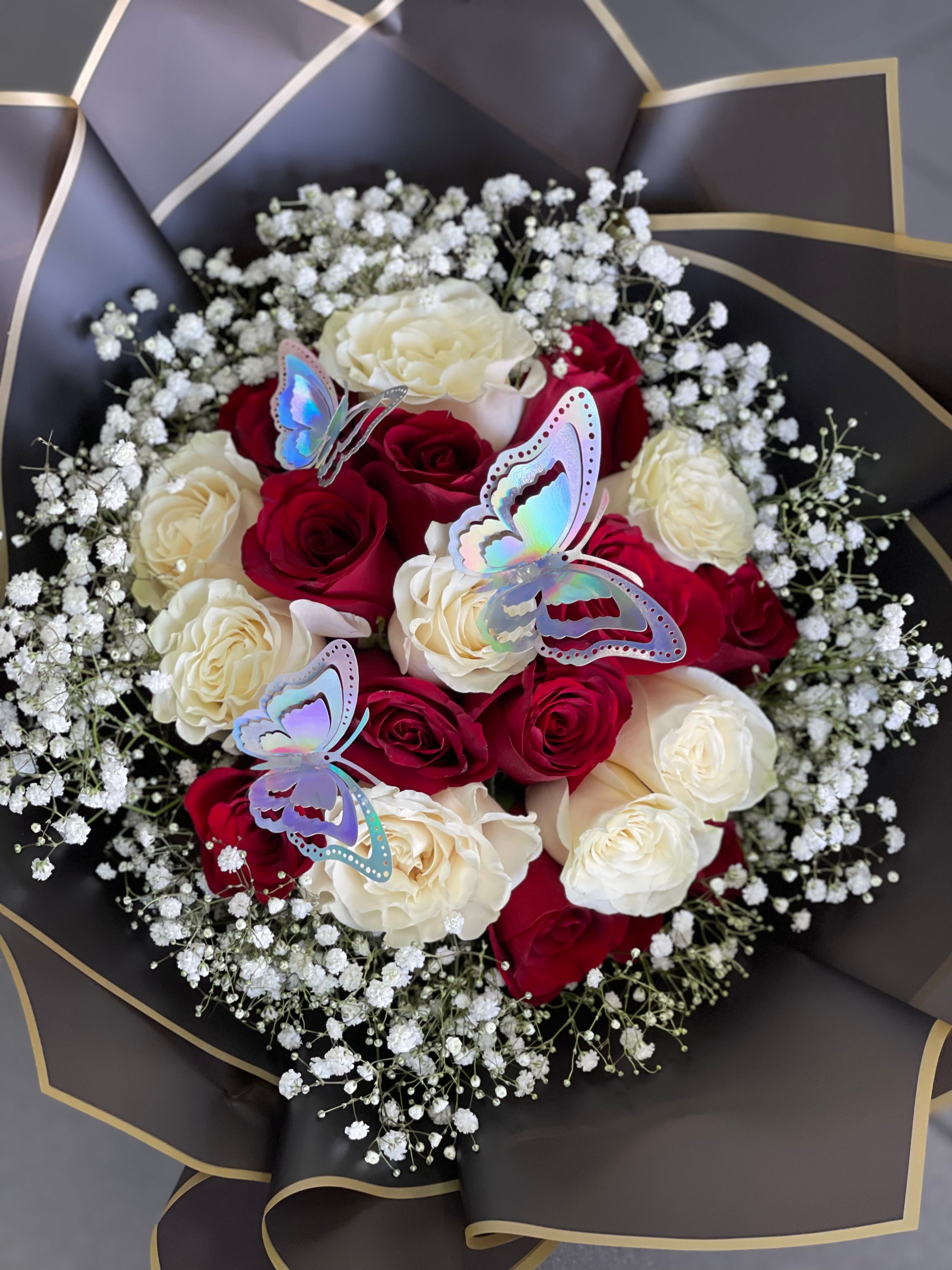 Bouquet of red and white roses with baby’s breath and butterfly picks