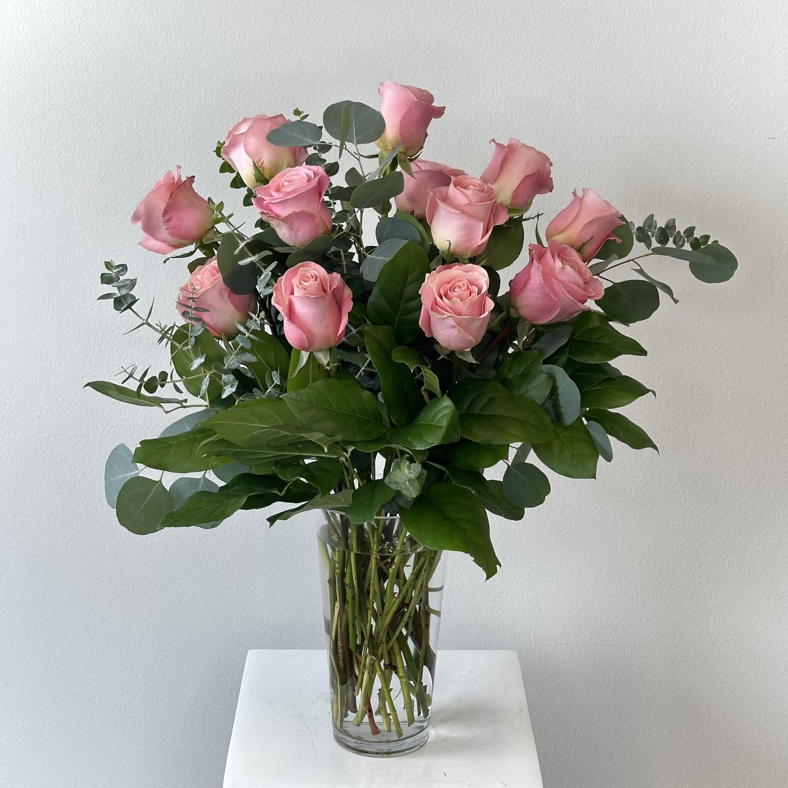 Dozen Pink Roses - Discover the timeless elegance of our Dozen Pink Roses – a classic bouquet featuring one dozen premium long-stem pink roses hand-selected for superior quality, vibrant color, and exceptional freshness. These luxurious premium pink roses boast velvety petals in soft, blushing shades that symbolize grace, admiration, gratitude, joy, and gentle affection – the perfect way to express appreciation, celebrate a birthday, anniversary, thank you, get well wishes, or simply say "you're special." Expertly arranged with lush complementary greenery to enhance the natural beauty and provide a fresh, balanced look, this stunning pink roses arrangement arrives in a classic clear glass vase (or your choice of elegant container upgrade). Ideal for romantic gestures, Mother's Day, Valentine's Day alternatives, or thoughtful everyday surprises, our 12 pink roses bouquet delivers lasting impressions and delightful fragrance. Sourced from top growers, these long stem pink roses ensure impressive presentation and extended vase life. Order pink rose delivery today for same-day or next-day arrival in most areas – because nothing conveys sweetness and femininity like a dozen beautiful pink roses. Keywords: dozen pink roses, premium pink roses, pink roses bouquet, 12 pink roses, long stem pink roses, pink flower arrangement, send pink roses, pink roses delivery.