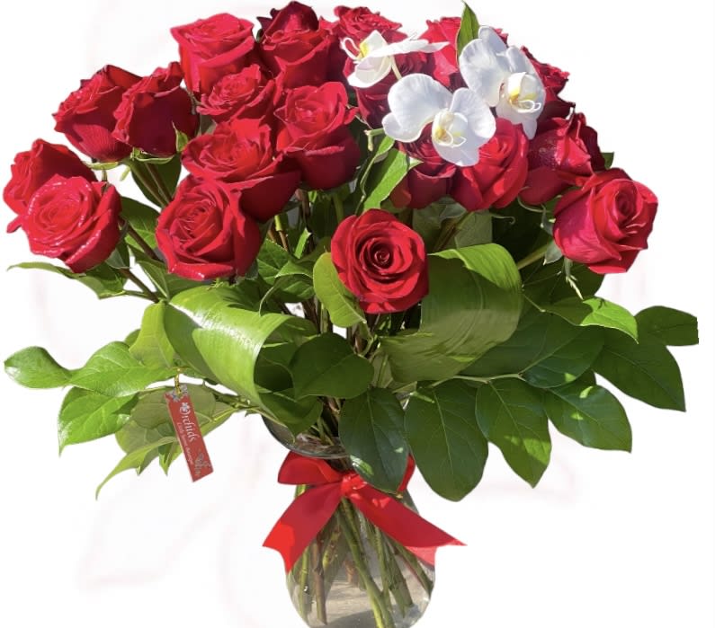 Bouquet of red roses with white orchids in a glass vase