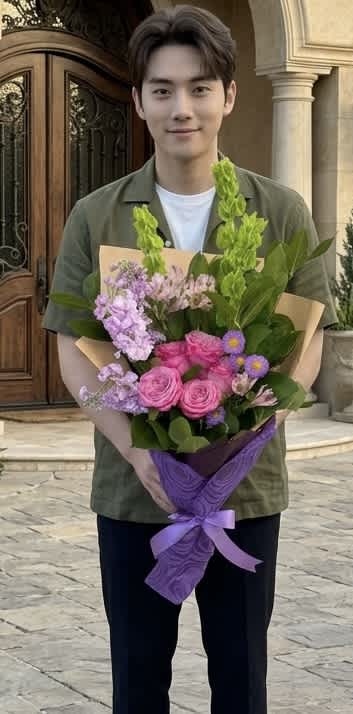 Person holding a bouquet of pink and purple flowers wrapped in purple paper