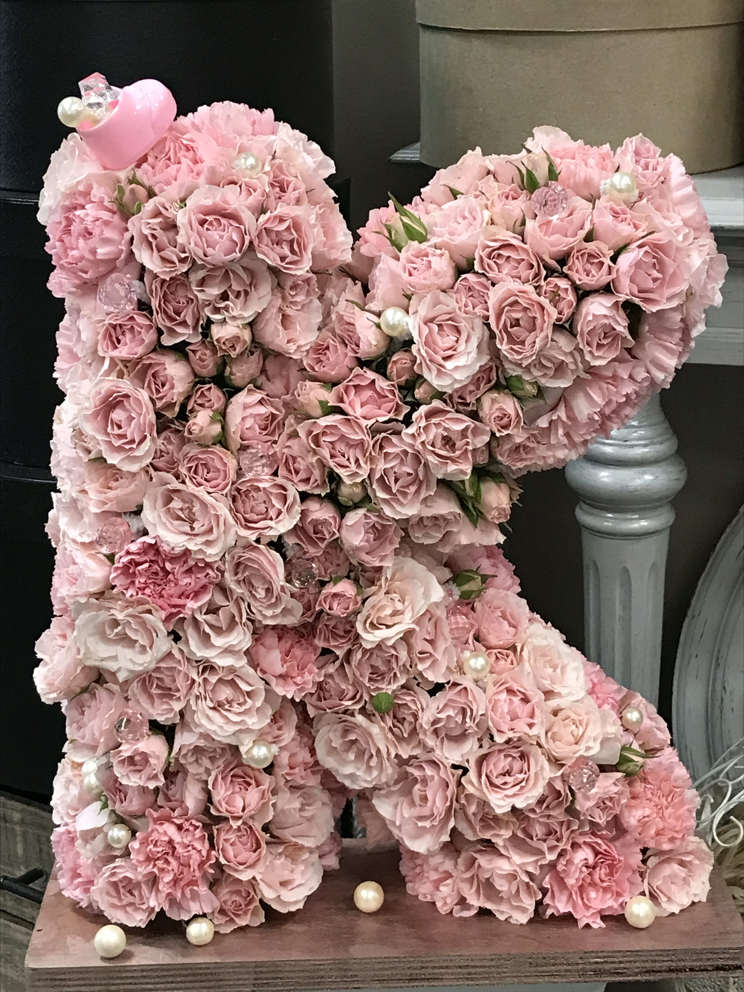 Pink rose teddy bear with pearl accents on a wooden base
