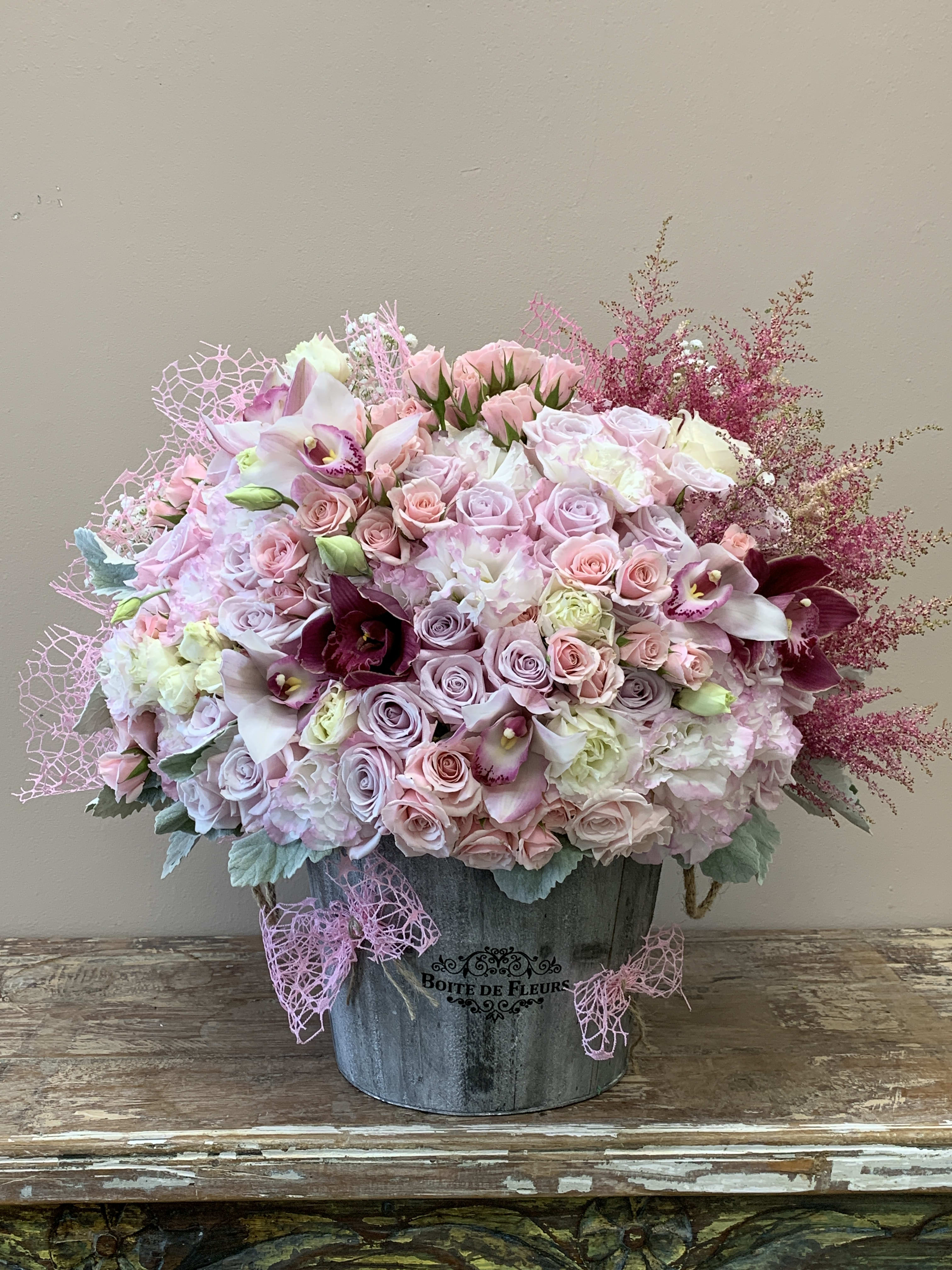 Pink and lavender floral arrangement in a metal bucket