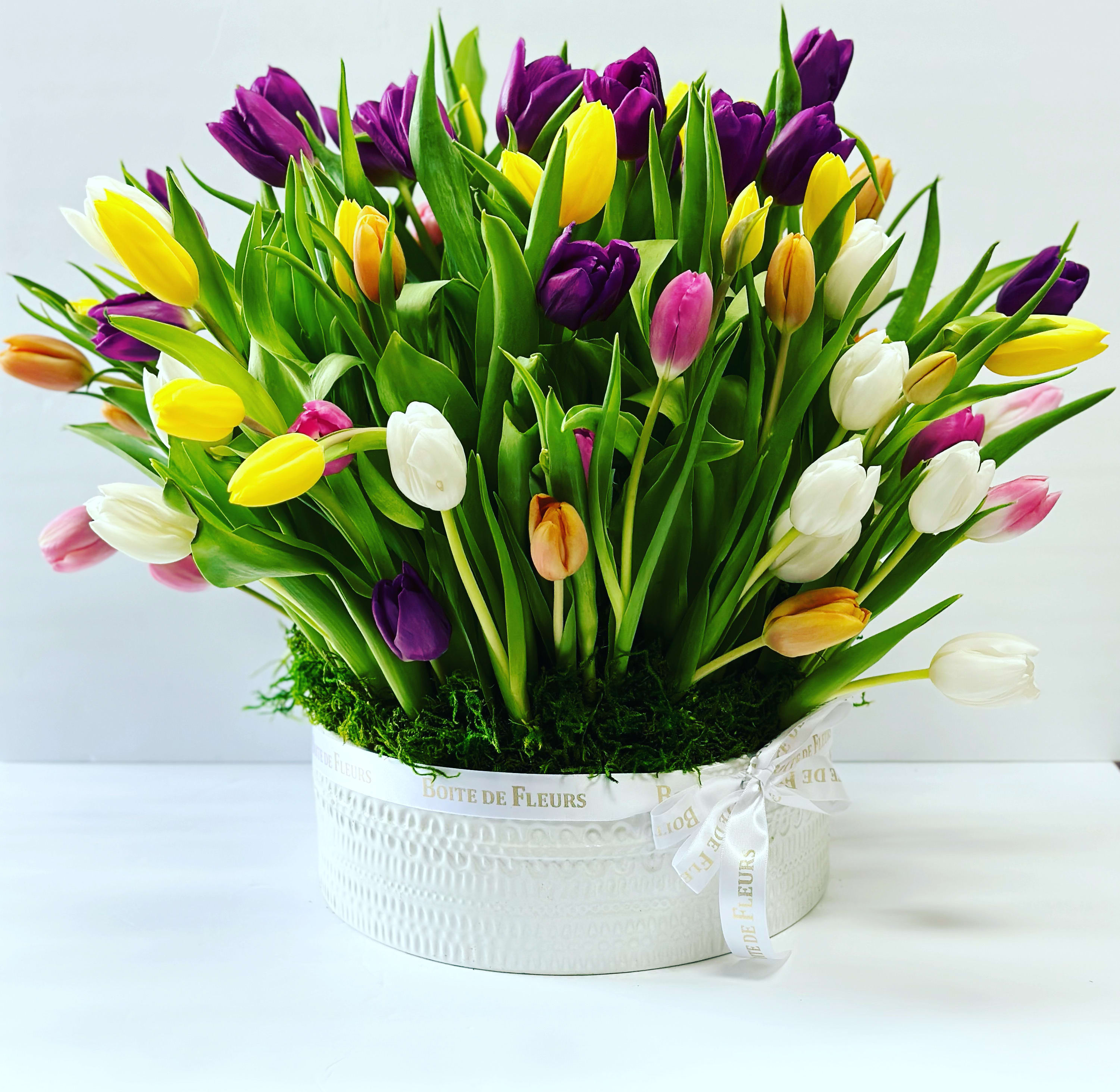 Colorful tulip bouquet in a white round box