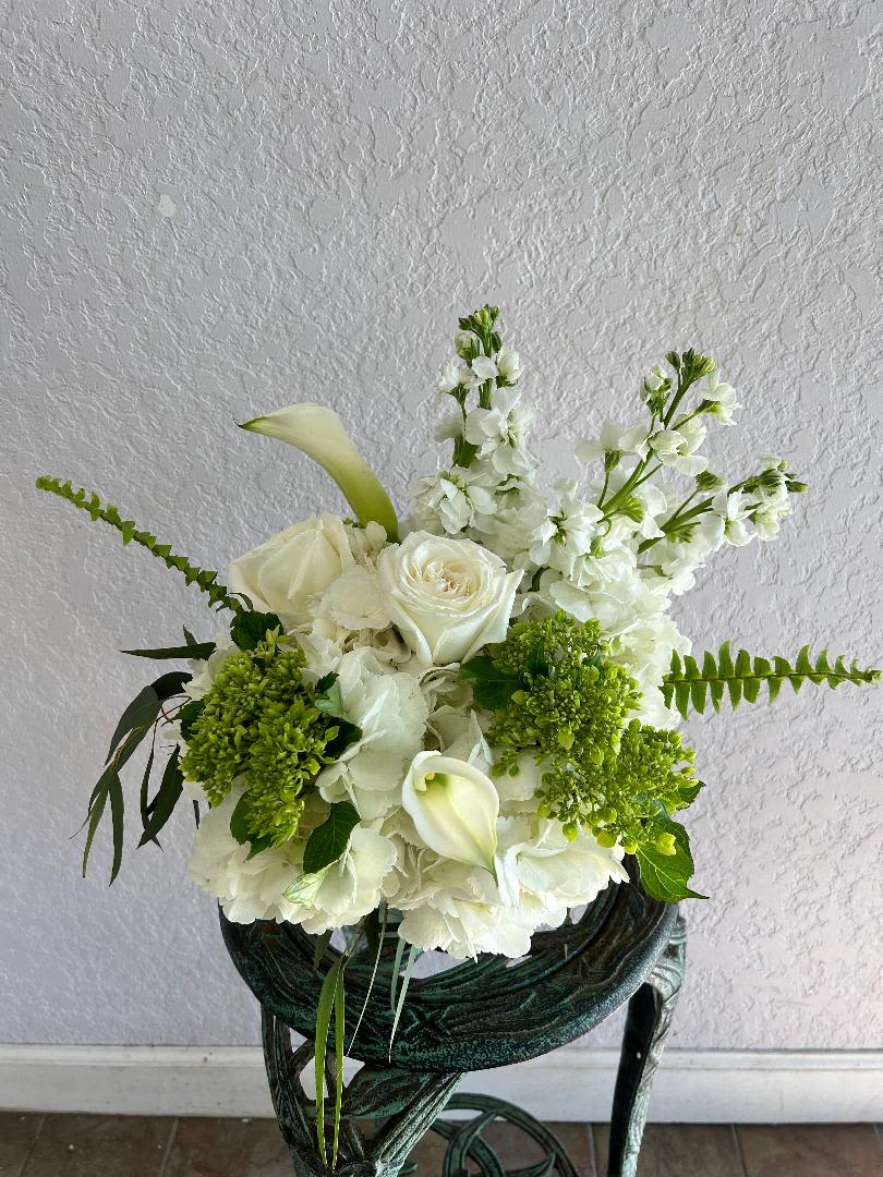 CFS145 - A short compact arrangment of high end white and green flowers such as hydrangeas, roses and other blooms. 
