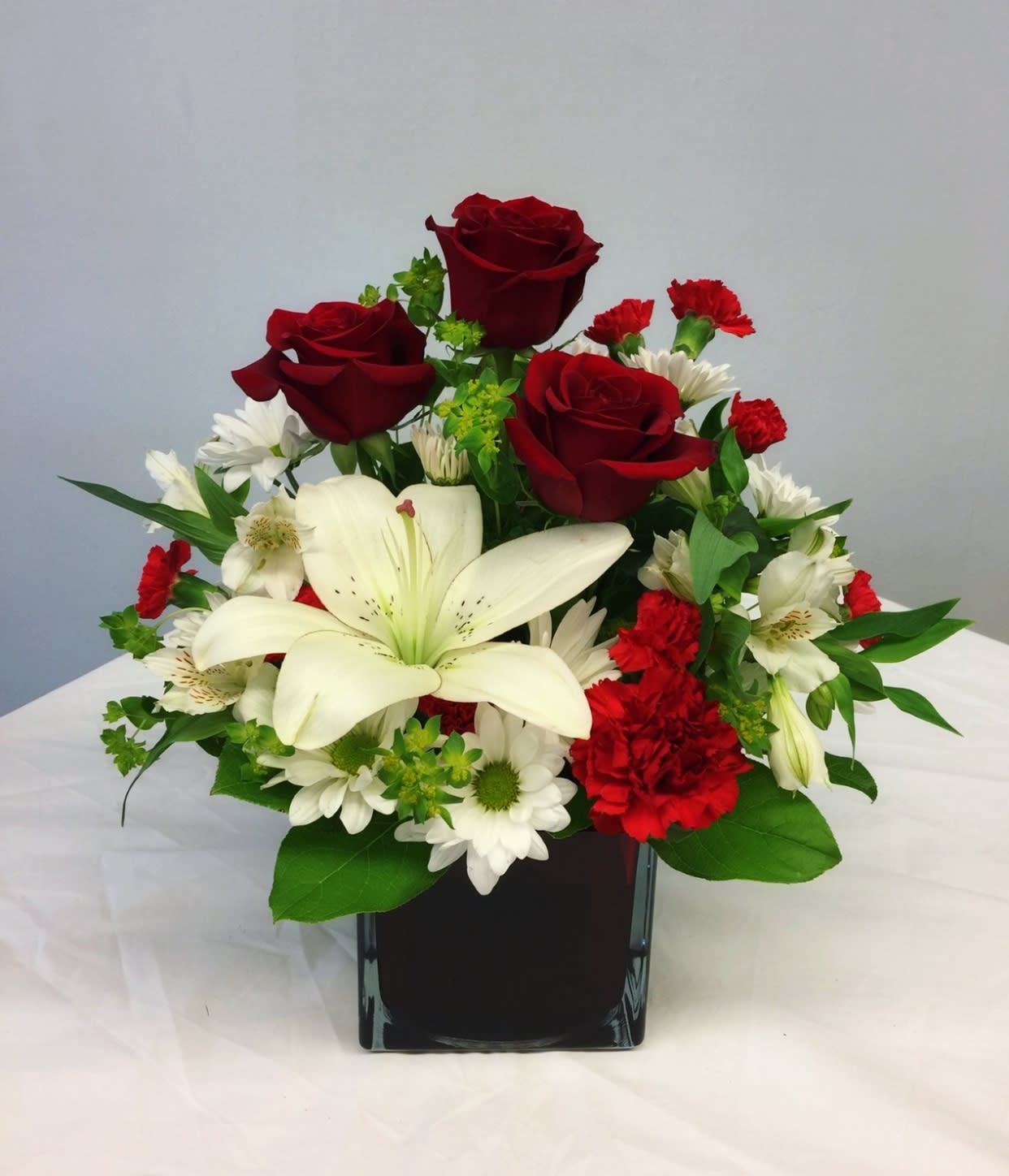 Red roses and white lilies in a black vase