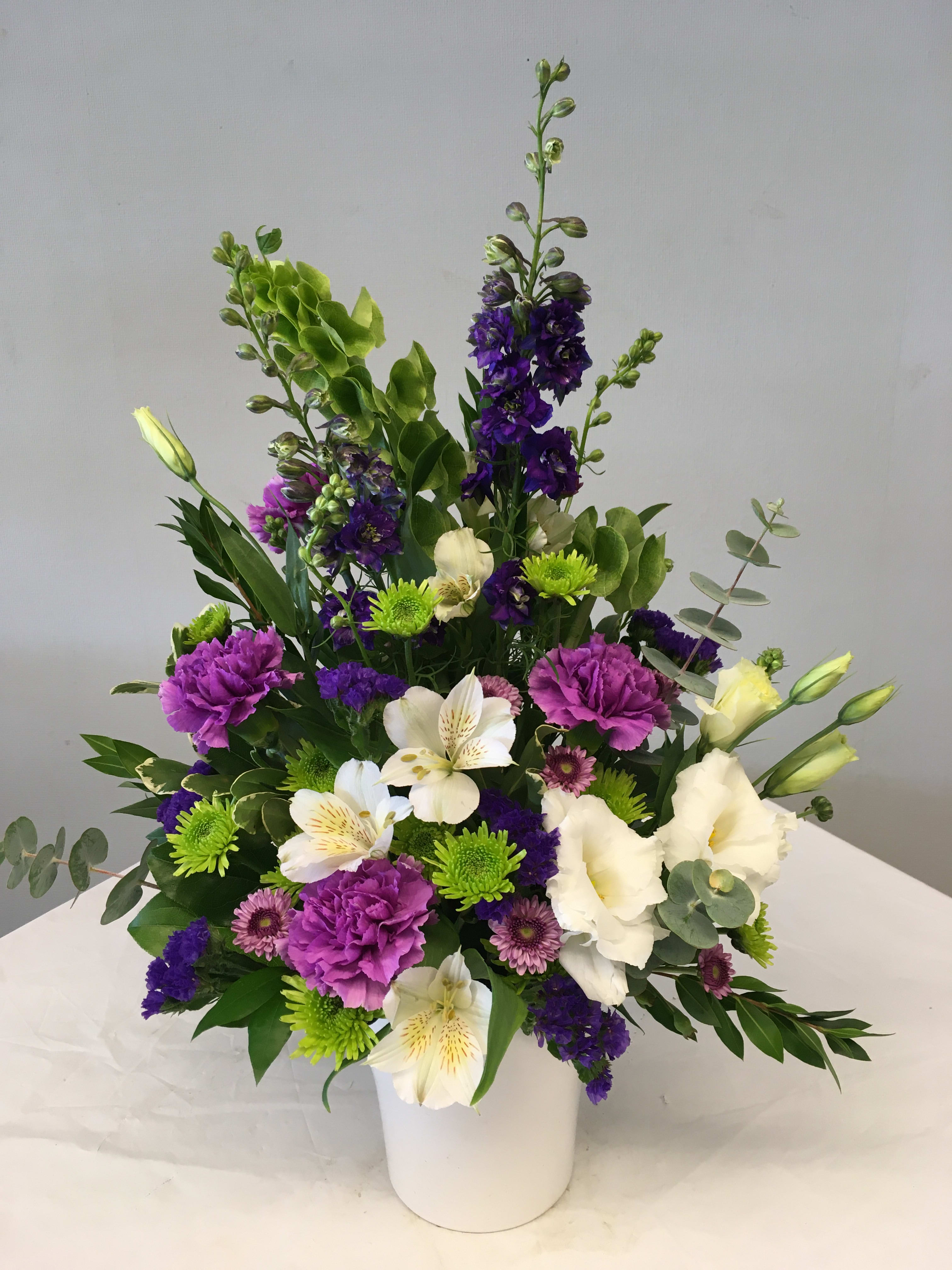 Mixed bouquet in a white vase with purple, white, and green flowers