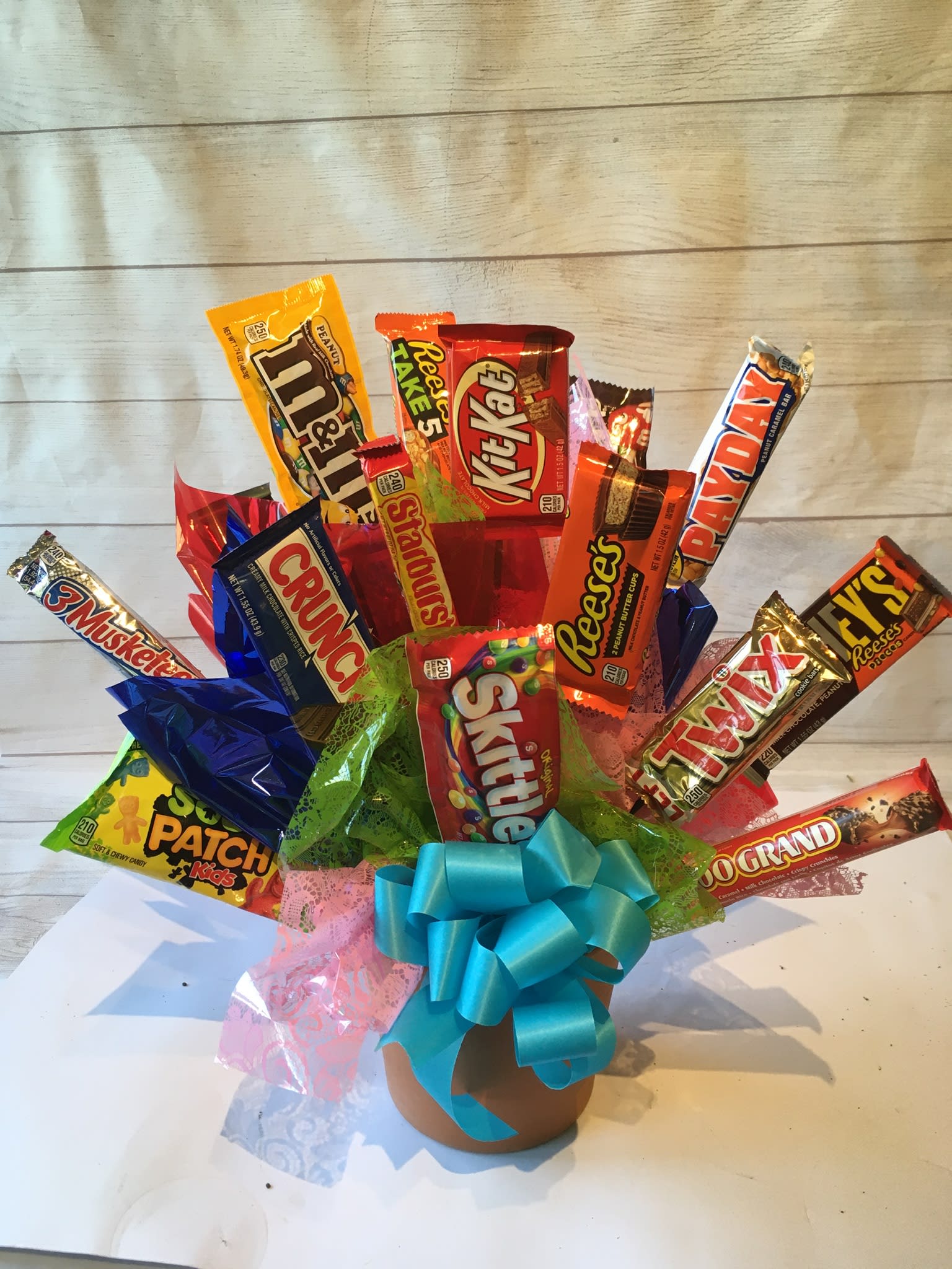 Candy bouquet in a pot with a blue ribbon bow