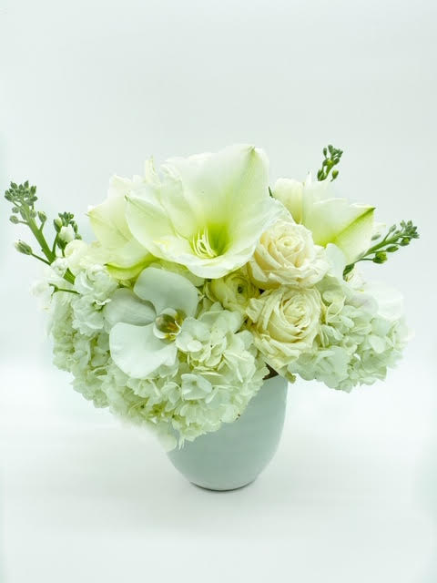 White floral arrangement in a white vase with large blooms